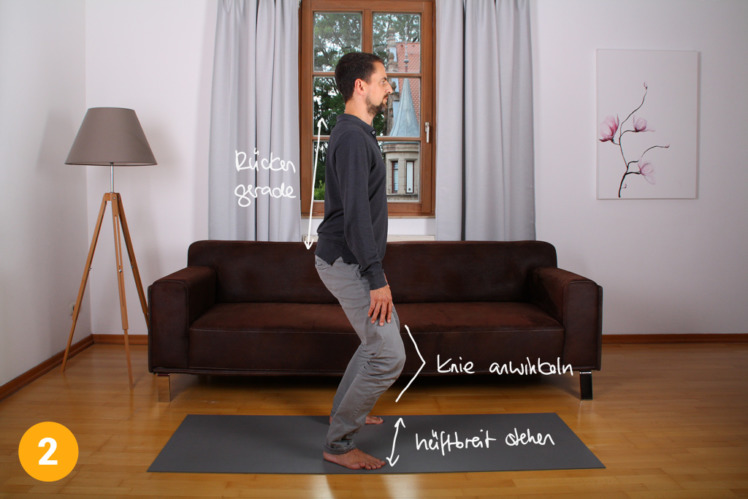 Gehe leicht in die Knie und bleibe in dieser Position die ganze Übung über. Die Füße stehen etwa 30 bis 40cm auseinander. Der Rücken bleibt gerade.